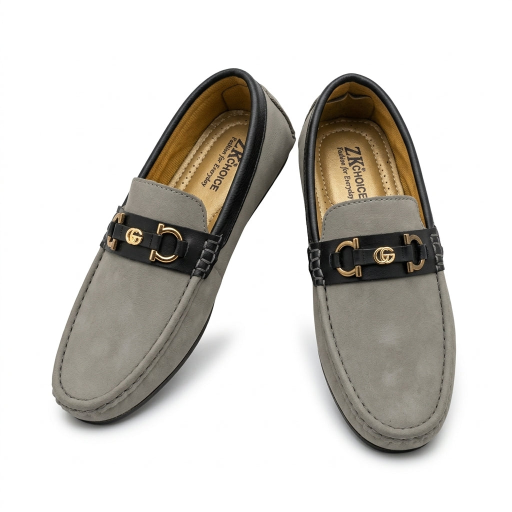 Grey nubuck two-tone horsebit driving loafer worn on cobblestone terrace with rolled charcoal chinos outdoor setting