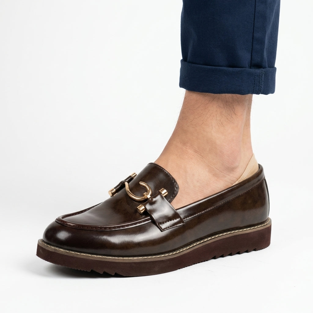 Dark brown leather horsebit loafer worn by man with navy trousers