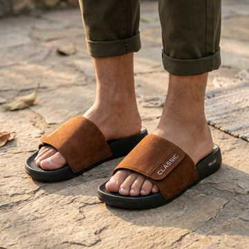 Person wearing brown classic slide sandals outdoors