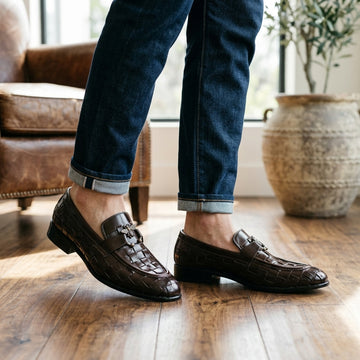 Dark brown woven leather bee-charm loafer worn with rolled dark jeans indoors